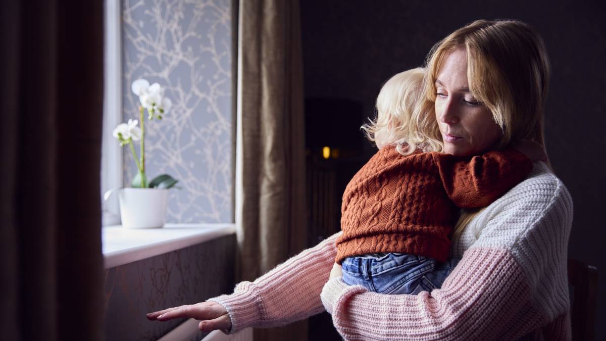 Mother holding child in front of window